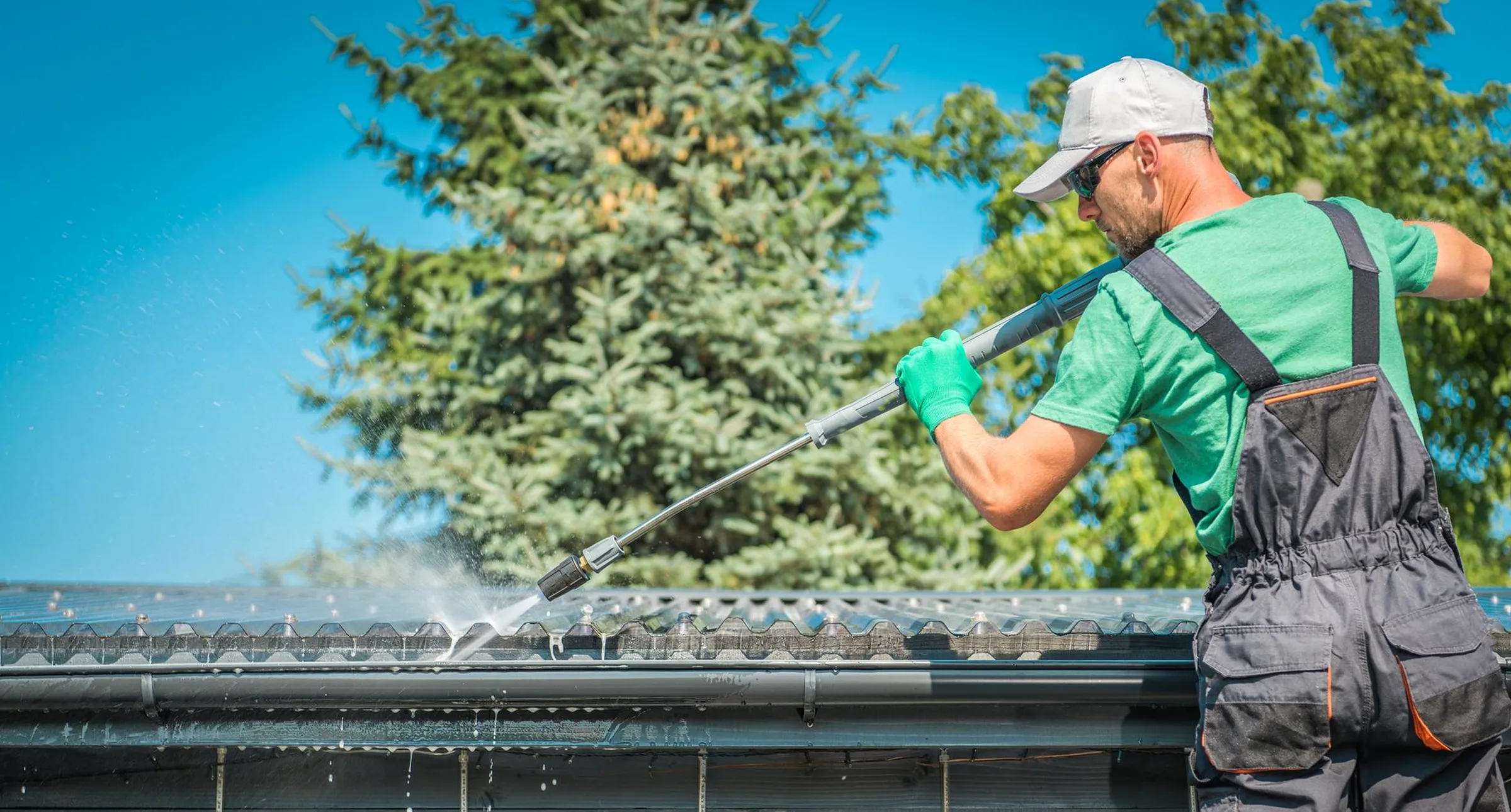 Technician soft-washing a roof